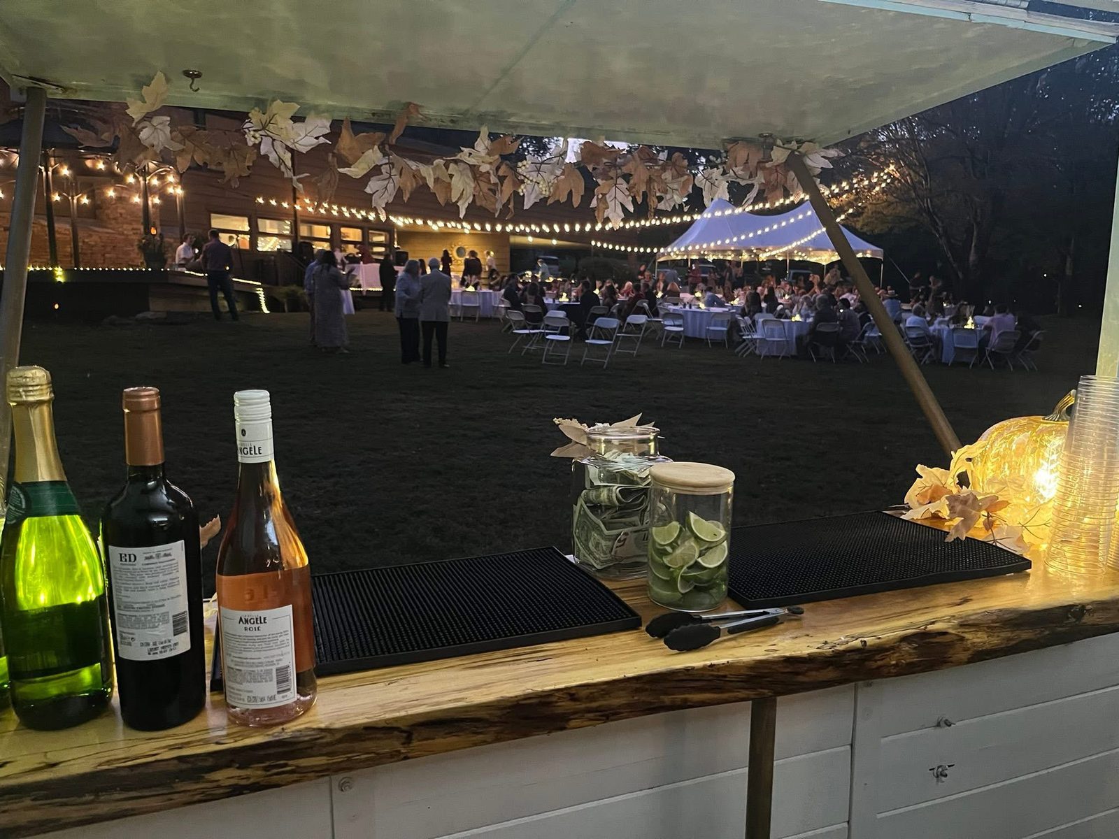 The mobile bar set up beside an outdoor wedding ceremony